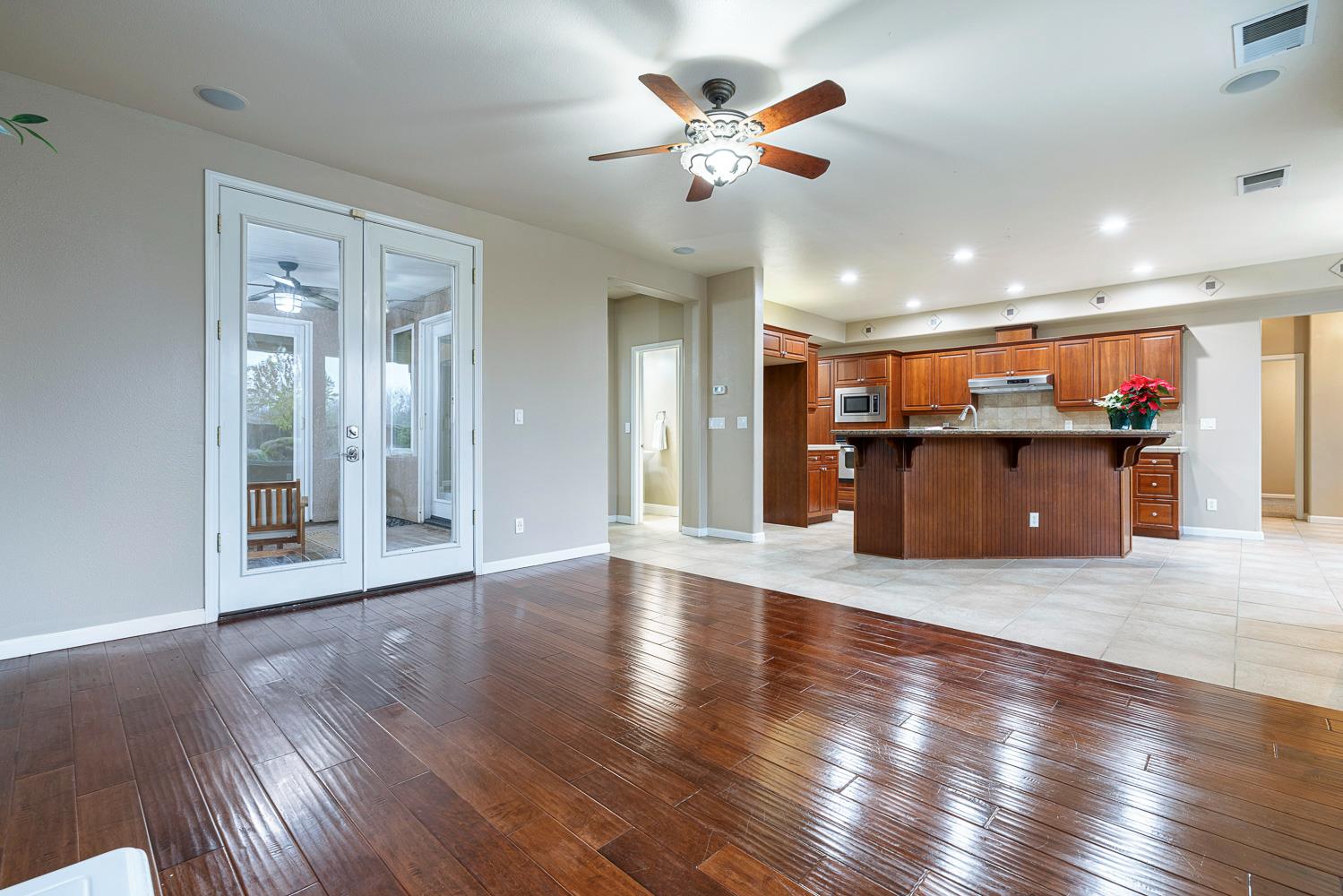 4674 North Arrow Ridge Way Clovis, CA 93619 - Photo 19 of 77 an empty room with wooden floor and a kitchen