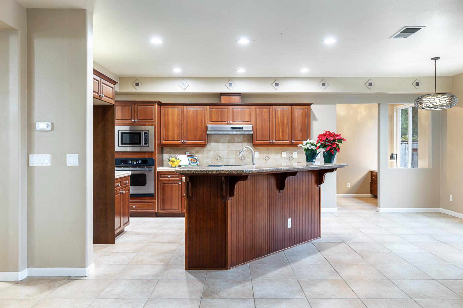4674 North Arrow Ridge Way Clovis, CA 93619 - Photo 21 of 77 a kitchen with stainless steel appliances granite countertop a sink counter and cabinets