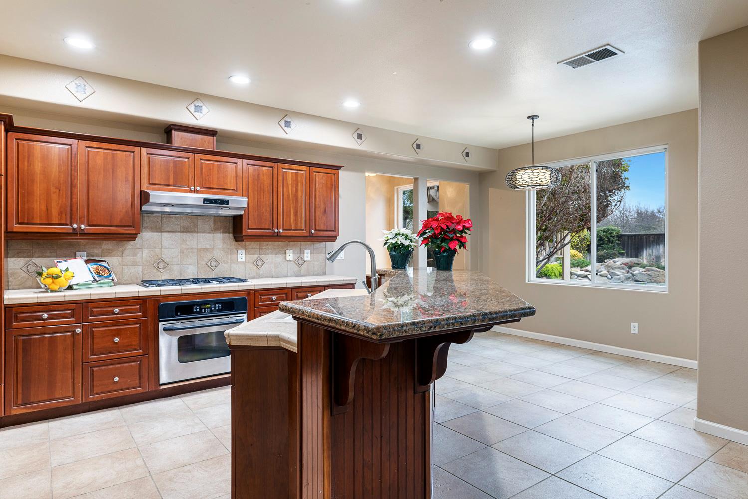 4674 North Arrow Ridge Way Clovis, CA 93619 - Photo 22 of 77 a kitchen with stainless steel appliances granite countertop a sink a stove and a wooden cabinets