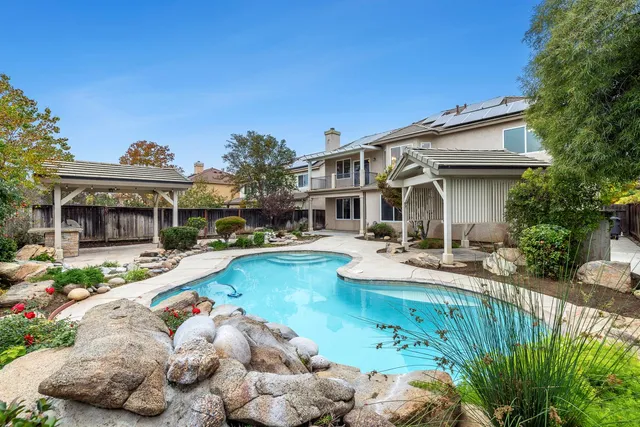 a view of an empty room with wooden floor fireplace and a window
