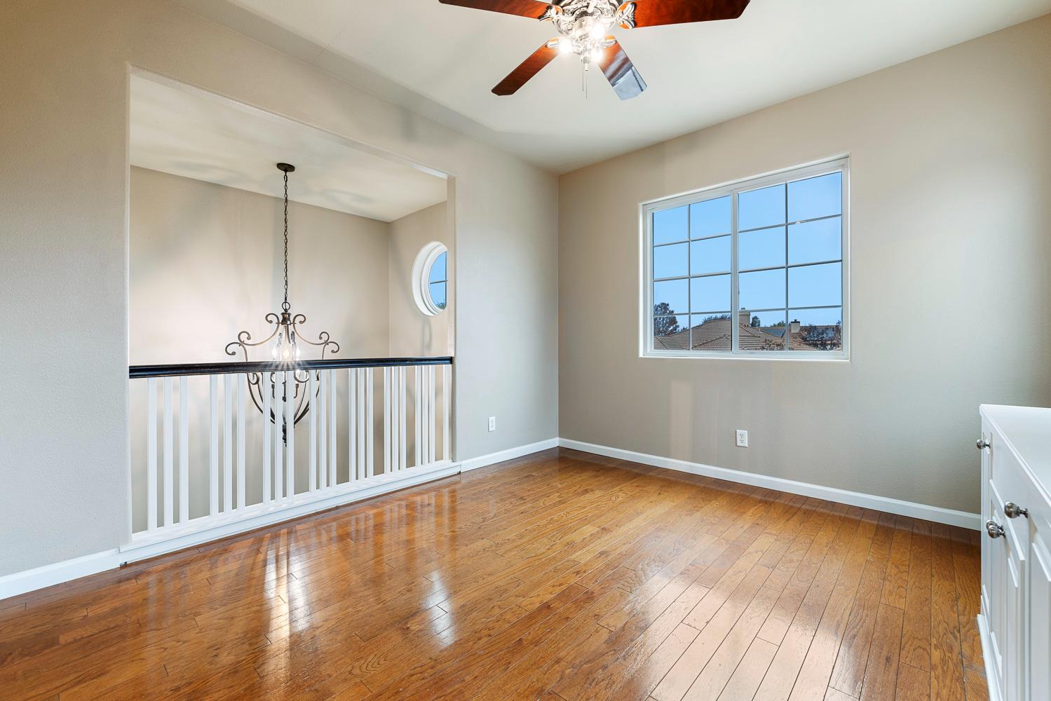 4674 North Arrow Ridge Way Clovis, CA 93619 - Photo 38 of 77 a view of an empty room with a window and wooden floor
