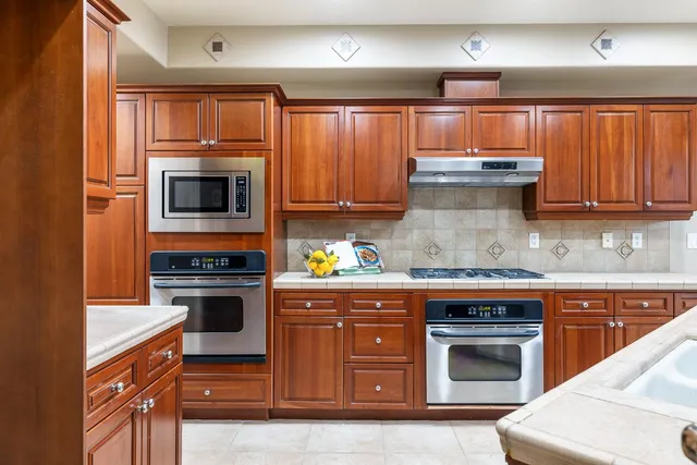 a view of an empty room with wooden floor fireplace and a window