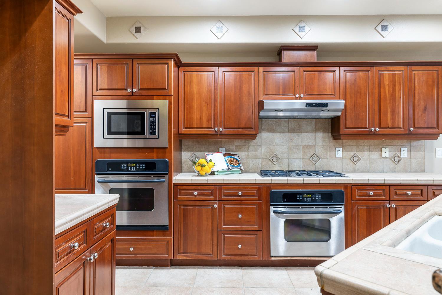 4674 North Arrow Ridge Way Clovis, CA 93619 - Photo 4 of 77 a kitchen with granite countertop wooden cabinets and stainless steel appliances