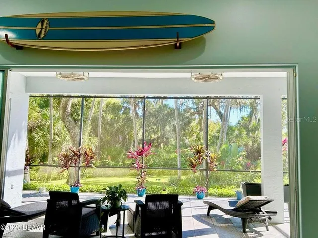 a living room with patio furniture and a floor to ceiling window