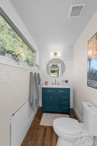 a bathroom with a toilet a sink and a mirror