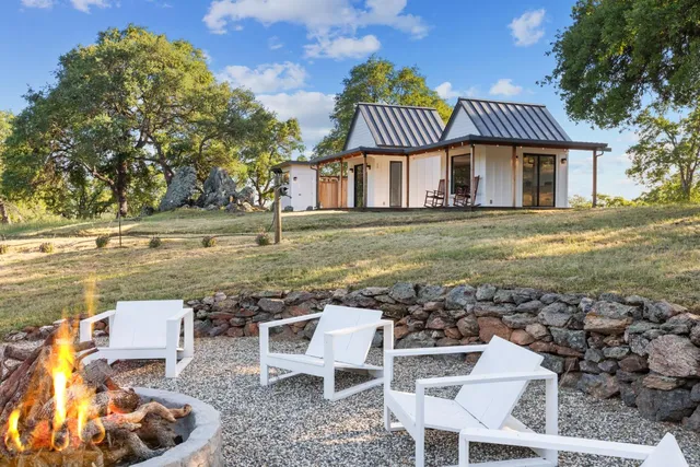 a view of a chairs and table in backyard of the house