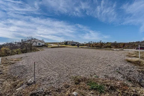 a view of a dry yard with wooden fence