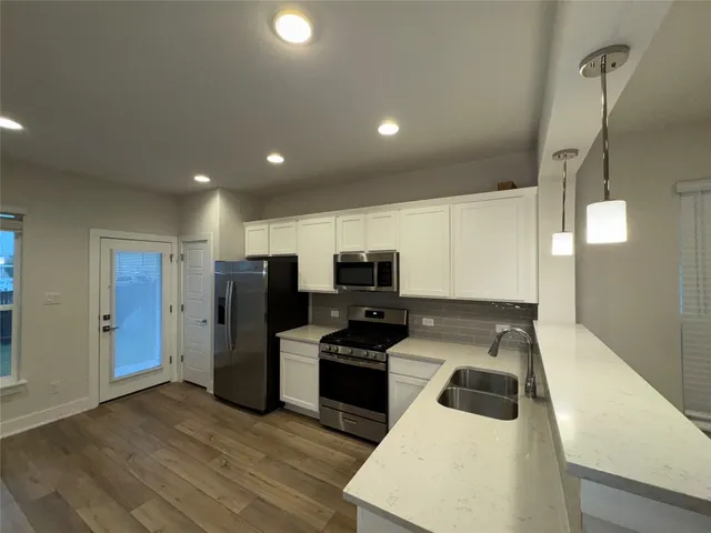 a kitchen with stainless steel appliances a stove a refrigerator and a sink