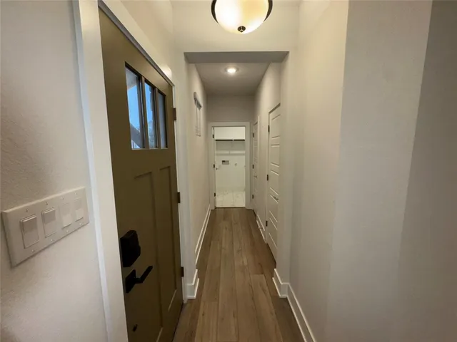 a view of a hallway with wooden floor and staircase