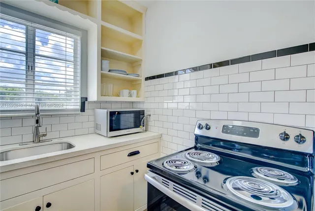 a kitchen with granite countertop a sink and a stove top oven