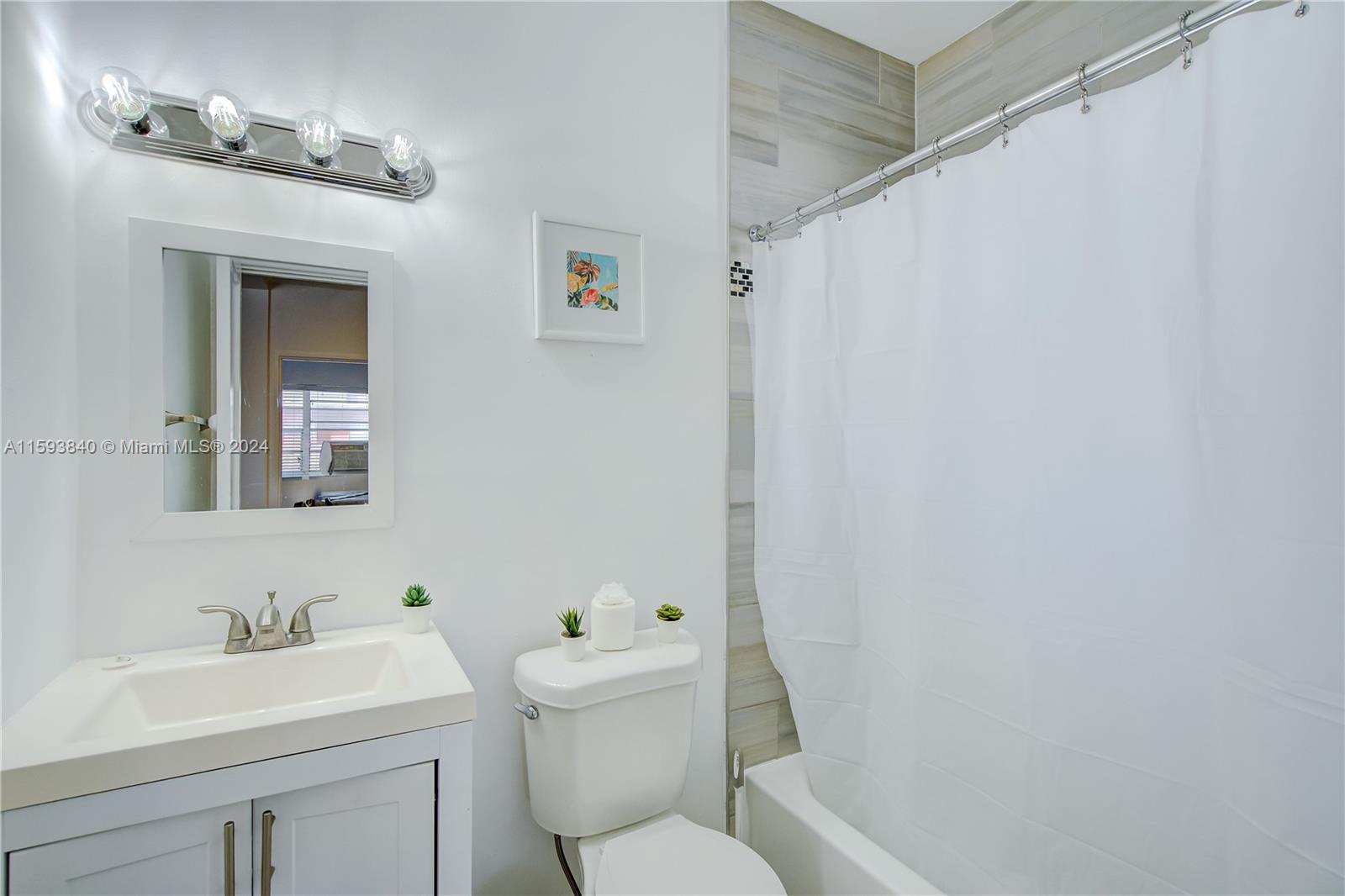 855 Southwest 7th Street Miami, FL 33130 - Photo 53 of 59 a bathroom with a toilet sink vanity tub and mirror