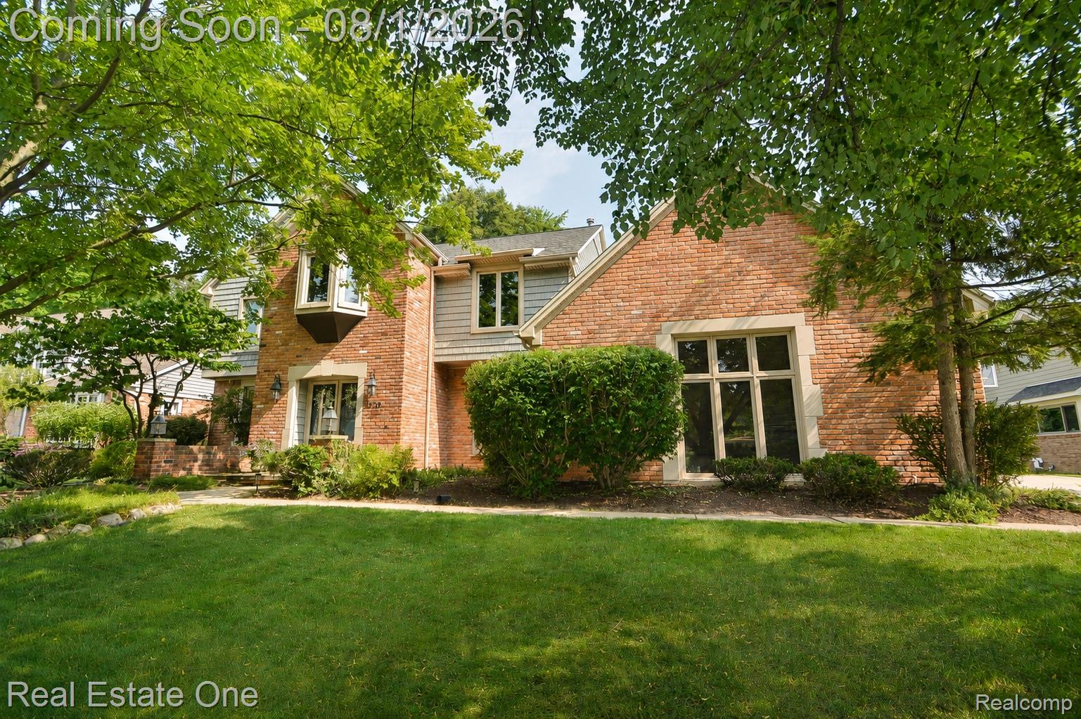 1370 Springwood Lane Rochester, MI 48309 - Photo 32 of 37 Brick and siding exterior featuring a prominent bay window, established landscaping, and a manicured lawn