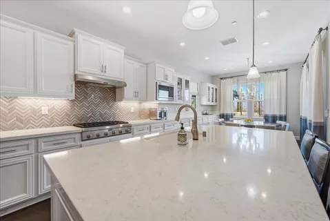 a kitchen with sink a stove and cabinets