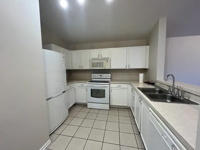 a kitchen with a stove sink and cabinets