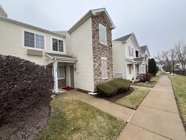 a view of a house with a yard and pathway
