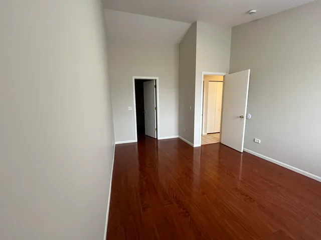 an empty room with wooden floor and closet