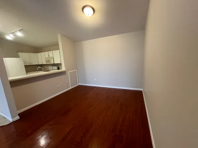 a view of a kitchen with wooden floor and electronic appliances