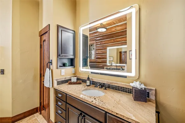 a bathroom with a granite countertop sink and a window