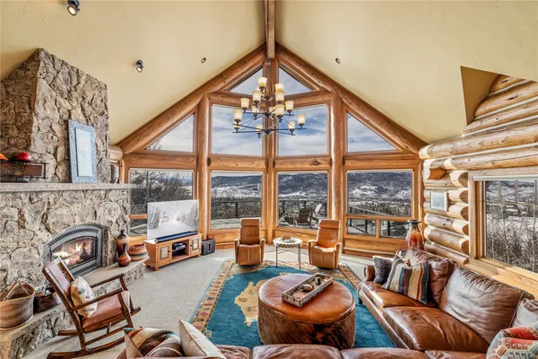 a living room with furniture a fireplace and a floor to ceiling window