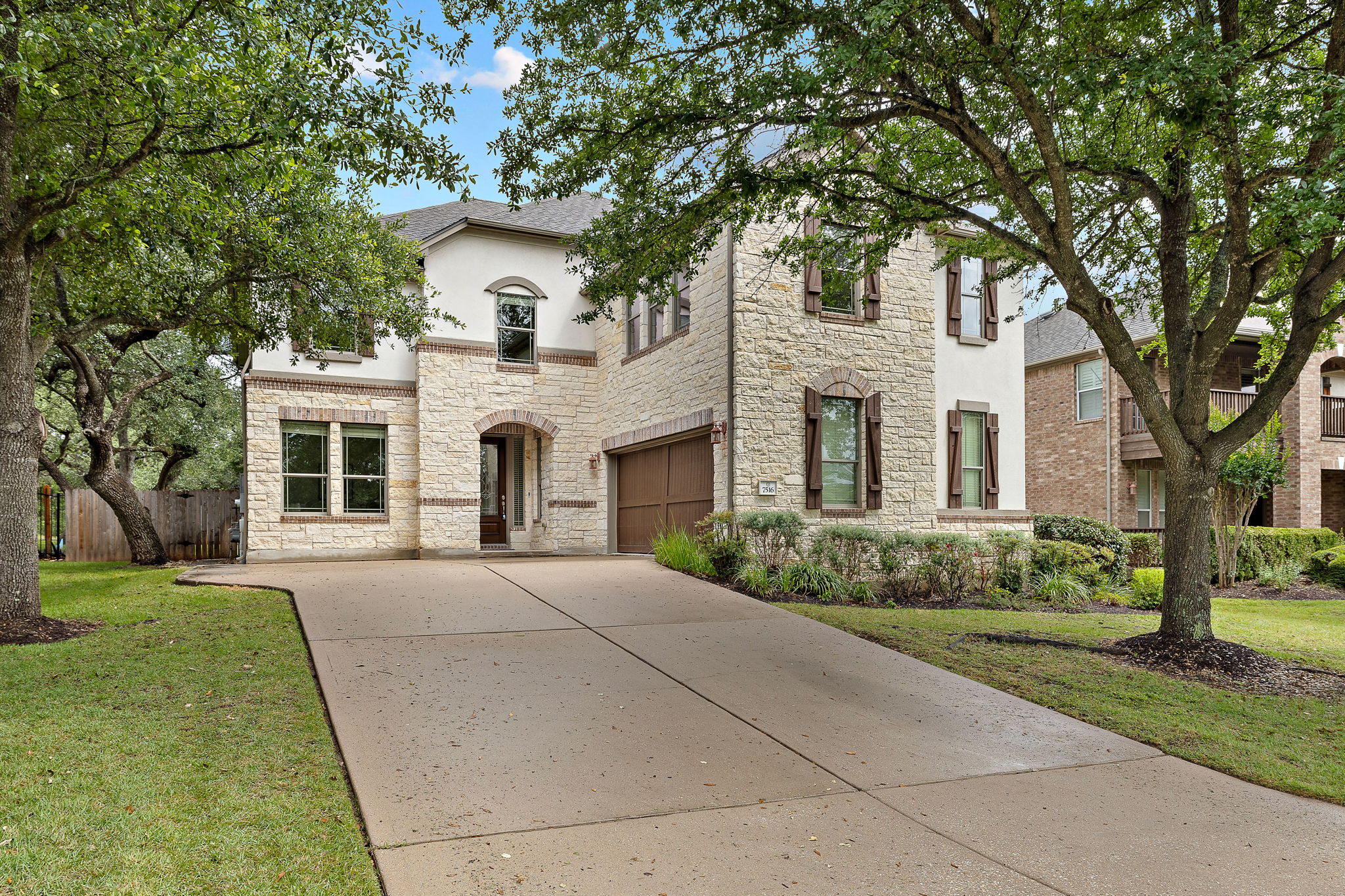 7516 Brecourt Manor Way Austin, TX 78739 - Photo 1 of 1 A grand stone and stucco facade welcomes you home, shaded by mature trees.