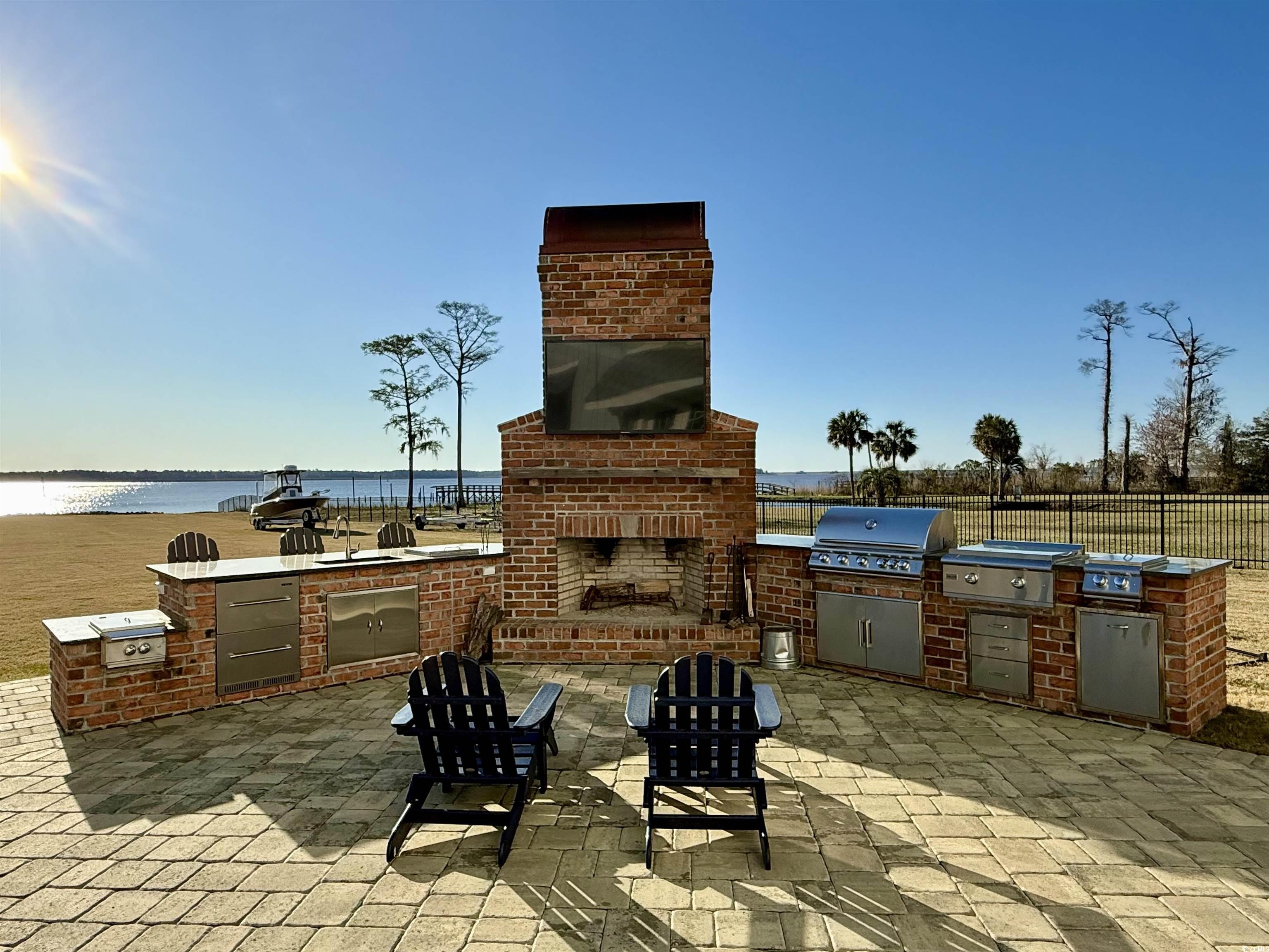 2425 South Bay Street Georgetown, SC 29440 - Photo 37 of 40 View of patio / terrace featuring grilling area, fence, exterior kitchen, and an outdoor brick fireplace