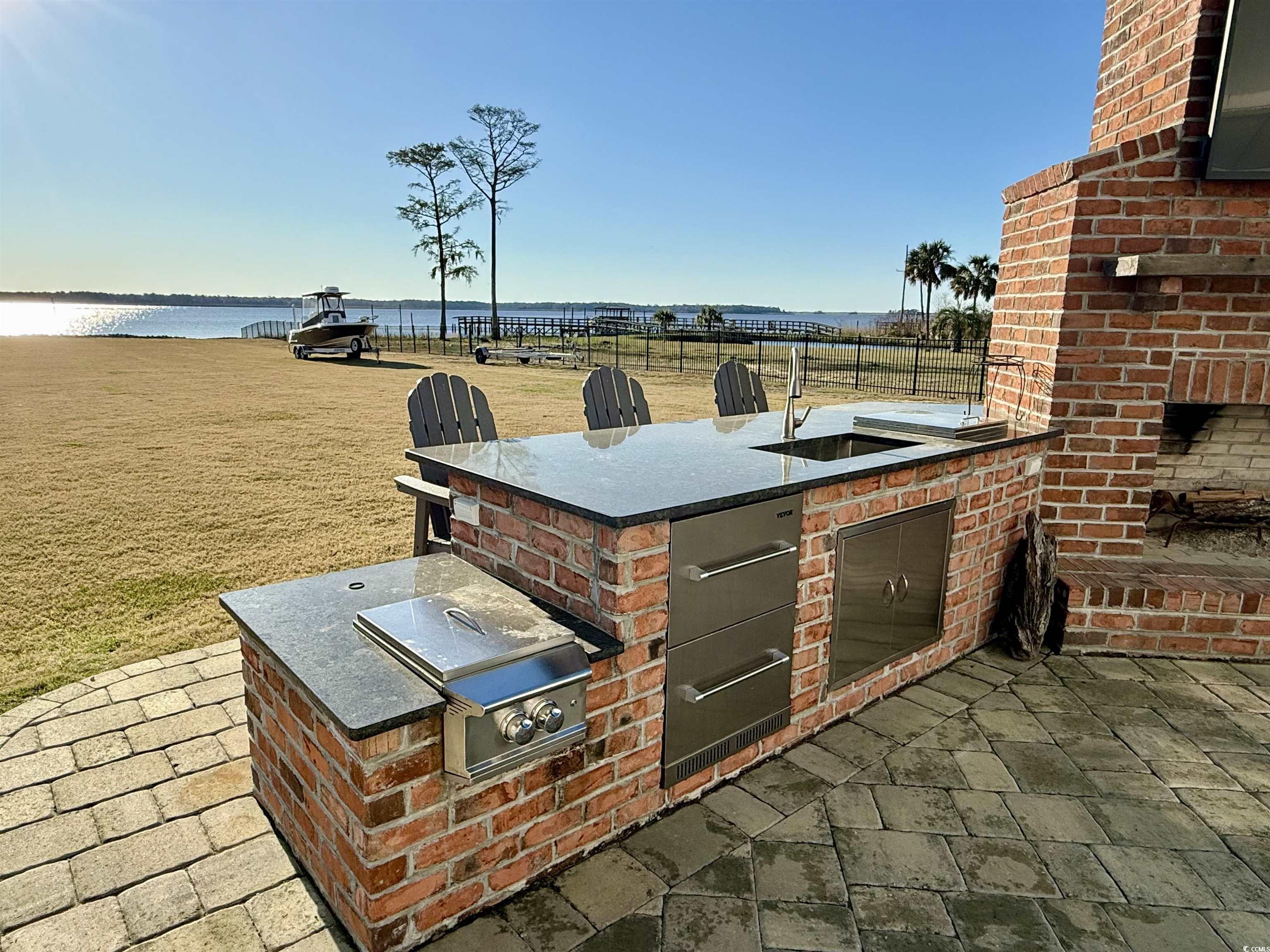 2425 South Bay Street Georgetown, SC 29440 - Photo 40 of 40 View of patio featuring exterior kitchen, fence, a water view, and a sink
