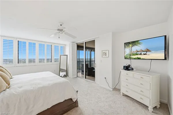 a spacious bedroom with a bed and a flat screen tv