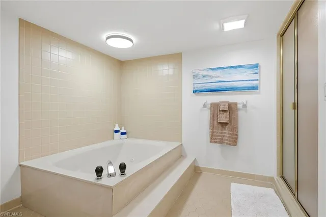 a view of a swimming pool with a lawn chairs and palm tree