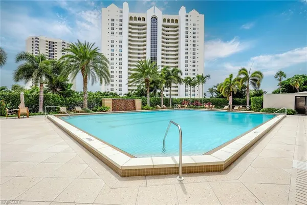 a view of swimming pool with garden and patio