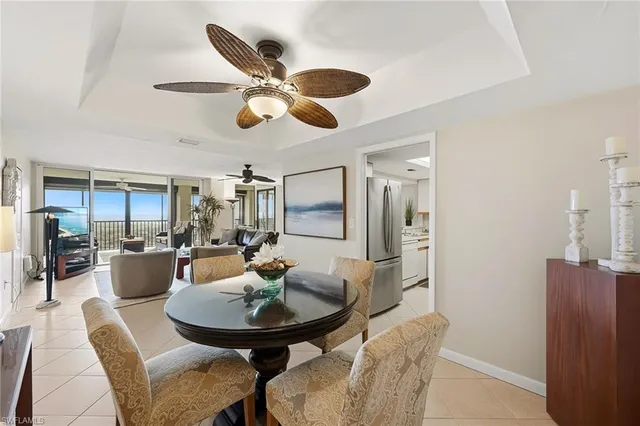 a living room with furniture a chandelier and kitchen view