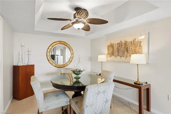 a living room with furniture a chandelier and kitchen view
