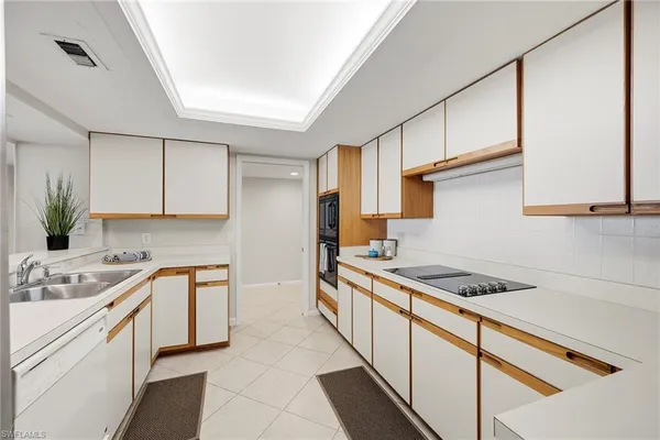 a kitchen with a sink a refrigerator and cabinets