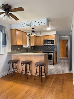 2900 East 101st Street Chicago, IL 60617 - Photo 13 of 27 a kitchen with stainless steel appliances granite countertop a stove and a wooden cabinets
