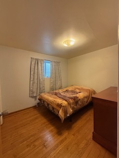 2900 East 101st Street Chicago, IL 60617 - Photo 16 of 27 a bedroom with a bed and wooden floor