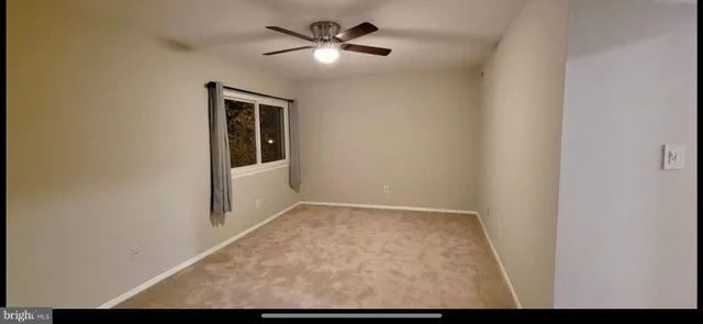 a view of a livingroom with a ceiling fan and window