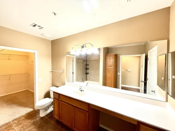 a bathroom with a sink vanity mirror and toilet