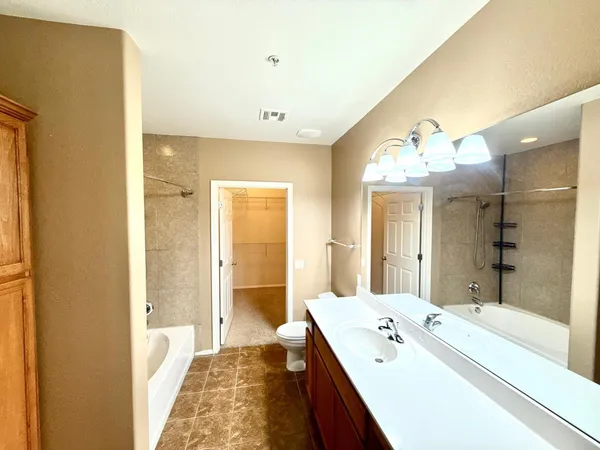a spacious bathroom with a bathtub sink and mirror