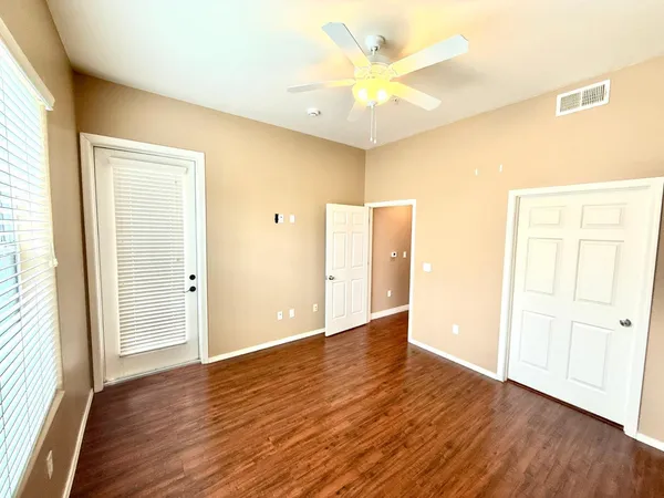 a view of an empty room with wooden floor