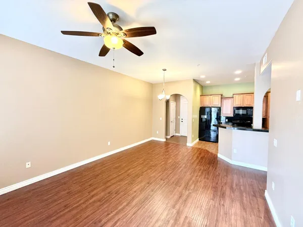 a view of an empty room and kitchen view
