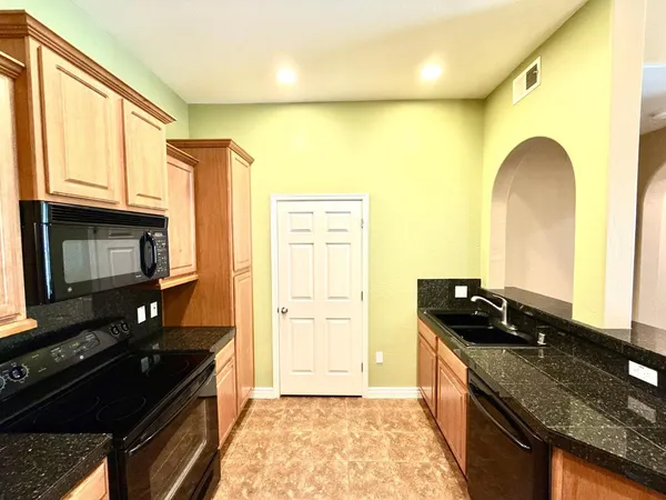 a kitchen with stainless steel appliances granite countertop a stove a sink and a microwave