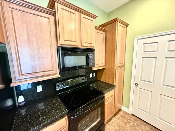 a kitchen with granite countertop a stove and a microwave