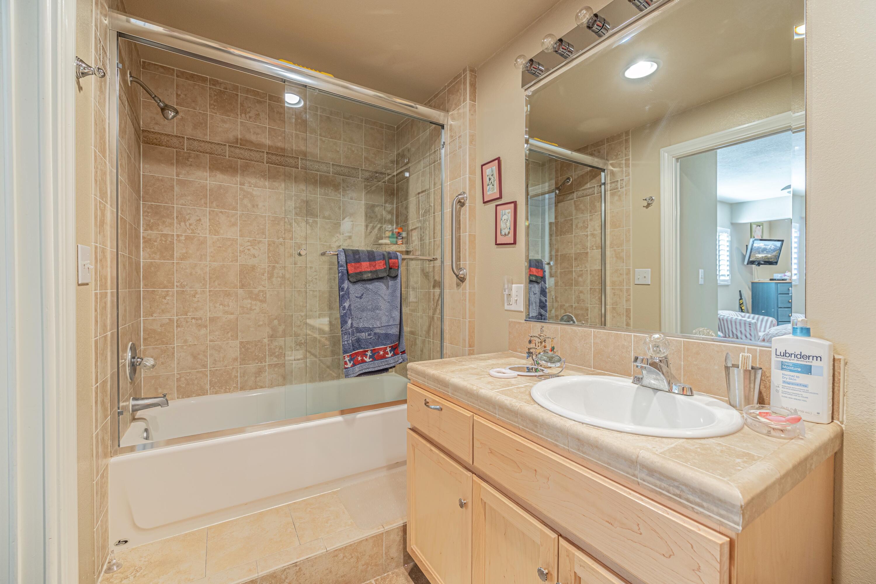 2153 West Ave K8 Lancaster, CA 93534 - Photo 21 of 31 a bathroom with a shower sink vanity and mirror