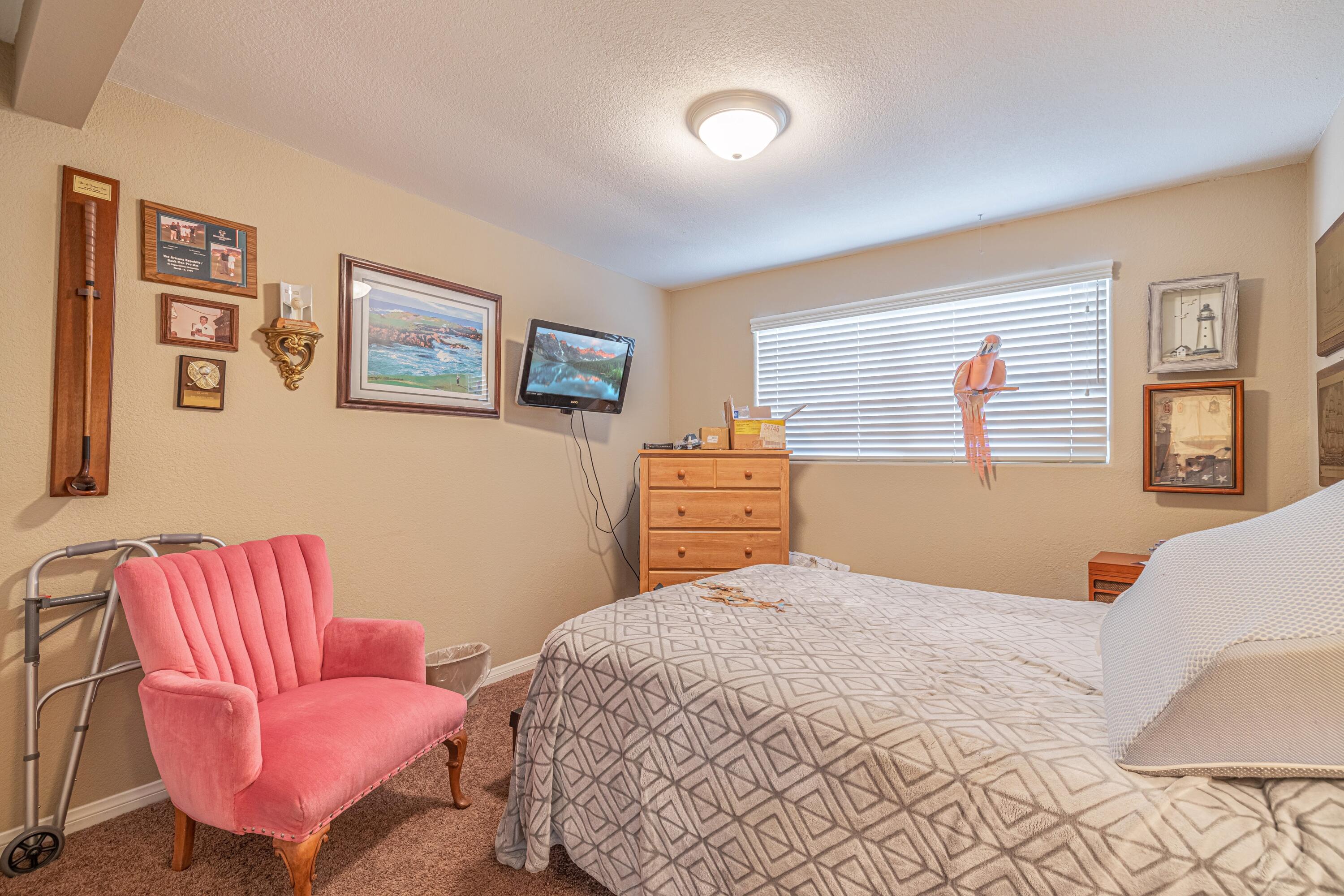 2153 West Ave K8 Lancaster, CA 93534 - Photo 22 of 31 a bedroom with a bed and dresser with chair