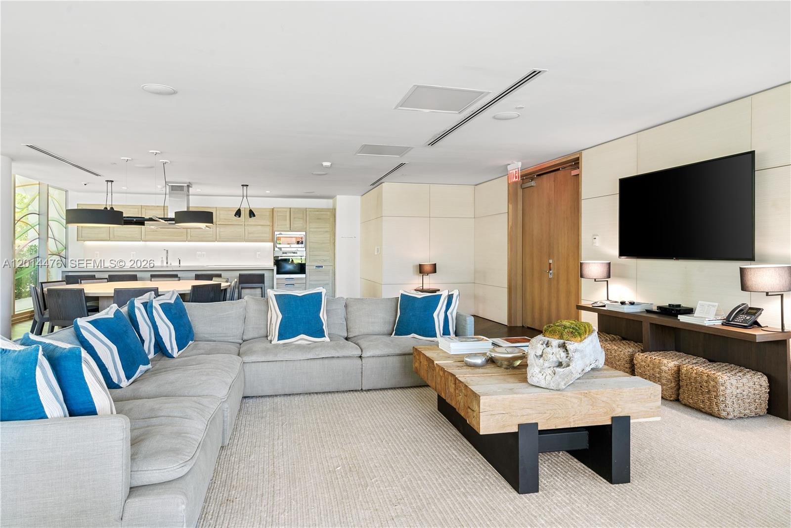360 Ocean Drive, Unit 1106S Key Biscayne, FL 33149 - Photo 32 of 67 Resident Lounge – A spacious lounge area features comfortable sectional seating, a media wall, and an open connection to the dining and kitchen areas. Natural textures and coastal blue accents create a relaxed, refined gathering space.