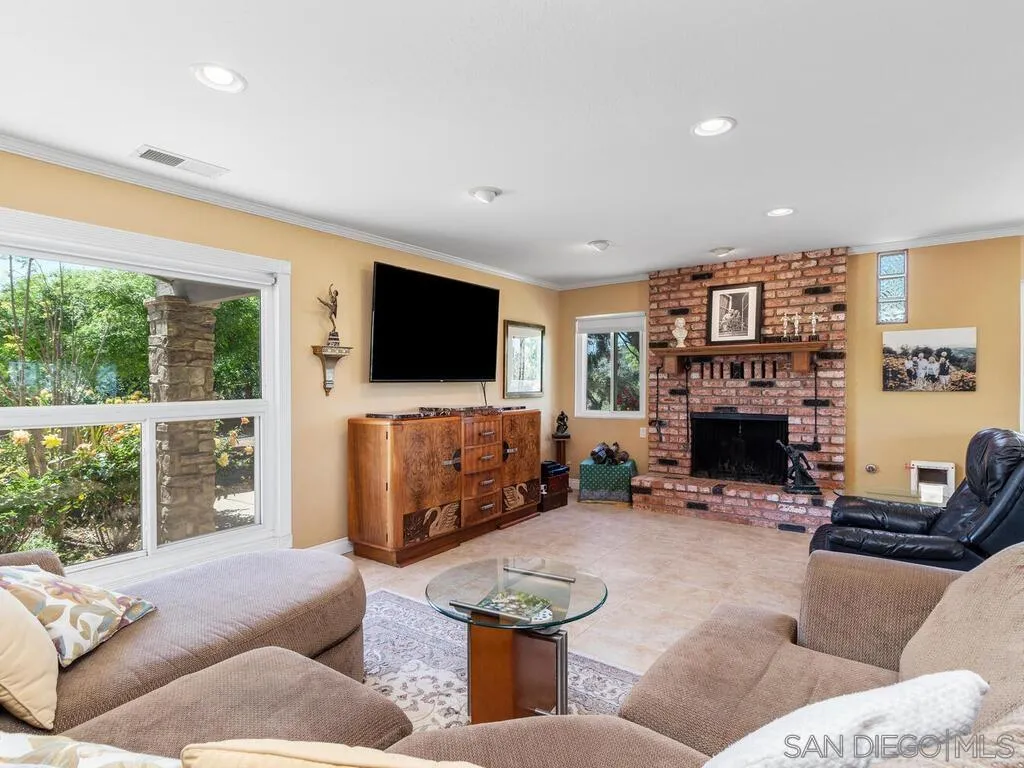 29513 Anthony Road Valley Center, CA 92082 - Photo 11 of 59 a living room with furniture a fireplace and a flat screen tv