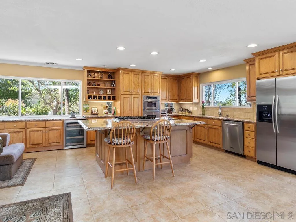 29513 Anthony Road Valley Center, CA 92082 - Photo 13 of 59 a kitchen with a sink a counter top space a large window and stainless steel appliances