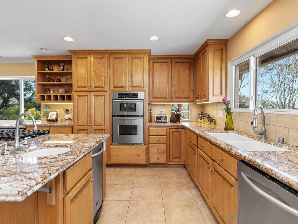 29513 Anthony Road Valley Center, CA 92082 - Photo 15 of 59 a kitchen with stainless steel appliances granite countertop a sink counter space cabinets and a large window