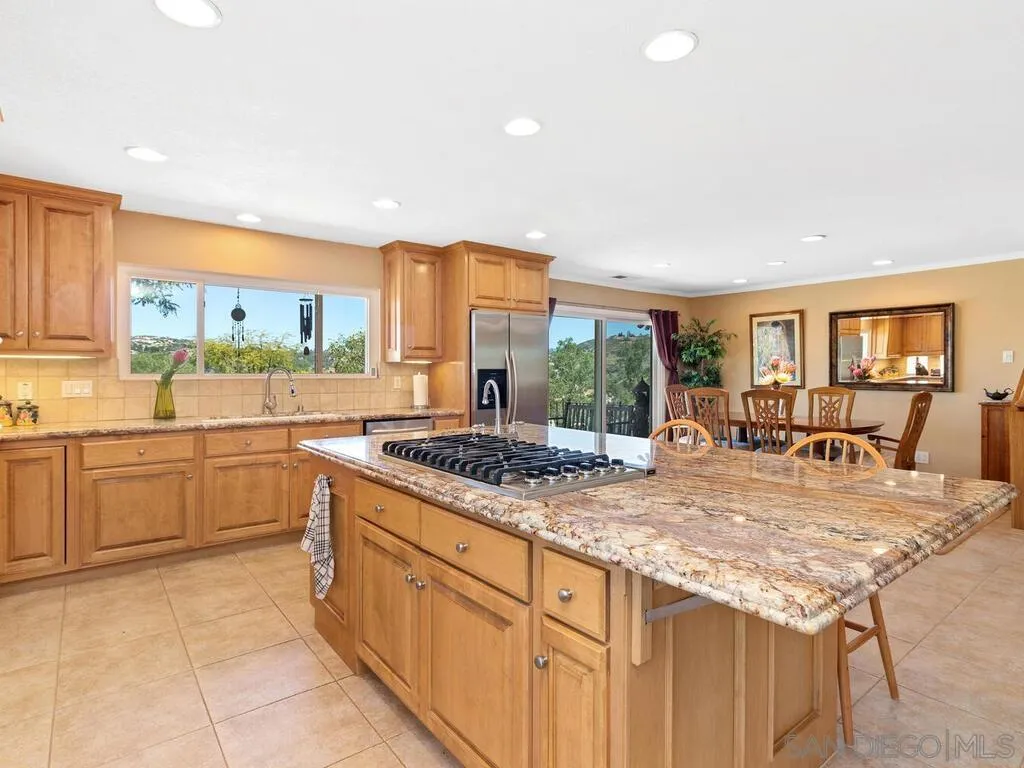 29513 Anthony Road Valley Center, CA 92082 - Photo 17 of 59 a kitchen with granite countertop a stove and cabinets