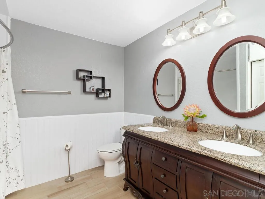 29513 Anthony Road Valley Center, CA 92082 - Photo 27 of 59 a bathroom with a granite countertop toilet a sink and a mirror