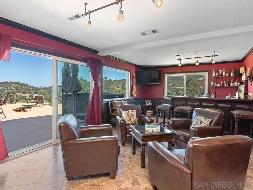 29513 Anthony Road Valley Center, CA 92082 - Photo 28 of 59 a living room with furniture a flat screen tv and a large window